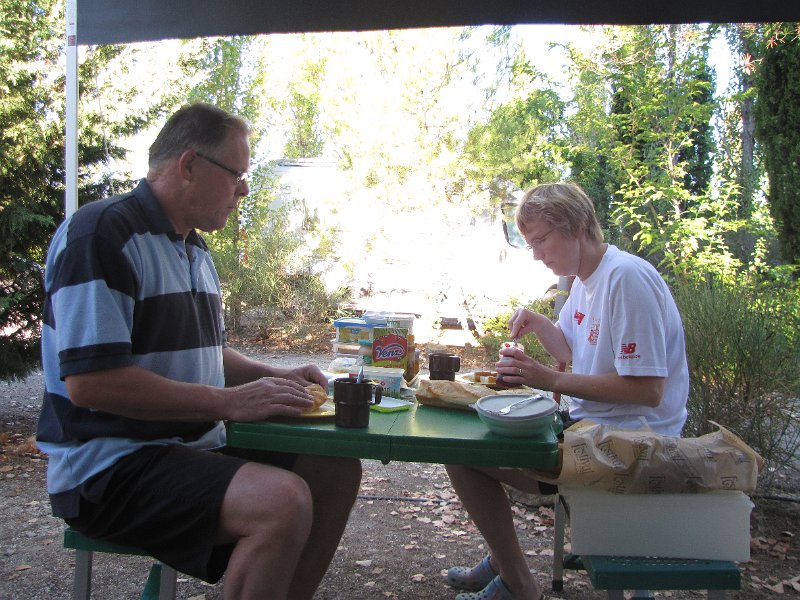 ontbijt op de camping.jpg - Woensdag, we smeren de boterhammen voor een dagje fietsen. Bij de VVV hebben we een kaart gehaald met daarop fietsroutes in de omgeving. Ingedeeld in 3 groepen: Famille, découverte en sportif. Om te wennen aan het heuvellandschap kiezen we een tocht uit de categorie Famille.